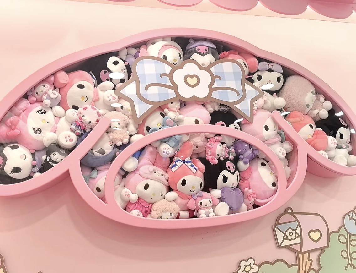ピンクの枠いっぱいに並ぶマイメロディたちのぬいぐるみ。