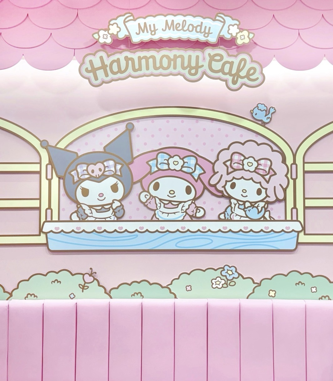 キャラクターのイラストを背景にしたピンクのベンチ席。